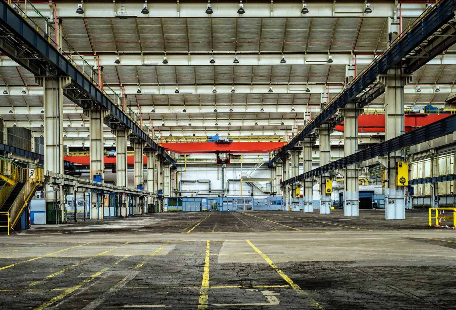 Große leere Industriehalle mit Hallenkran und Stahlstützen